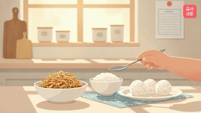 식탁 위 멸치볶음 그릇과 밥, 동그란 주먹밥을 숟가락으로 뜨려는 아이 손 그림