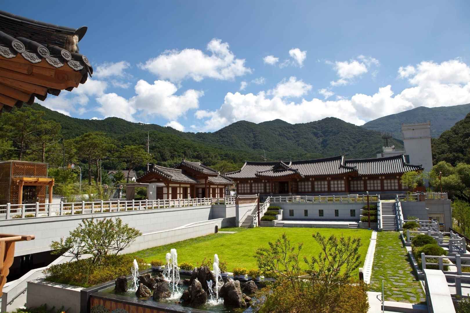 광주 전통문화관 전통 한옥 건물과 푸른 잔디, 분수가 있는 정원 전경