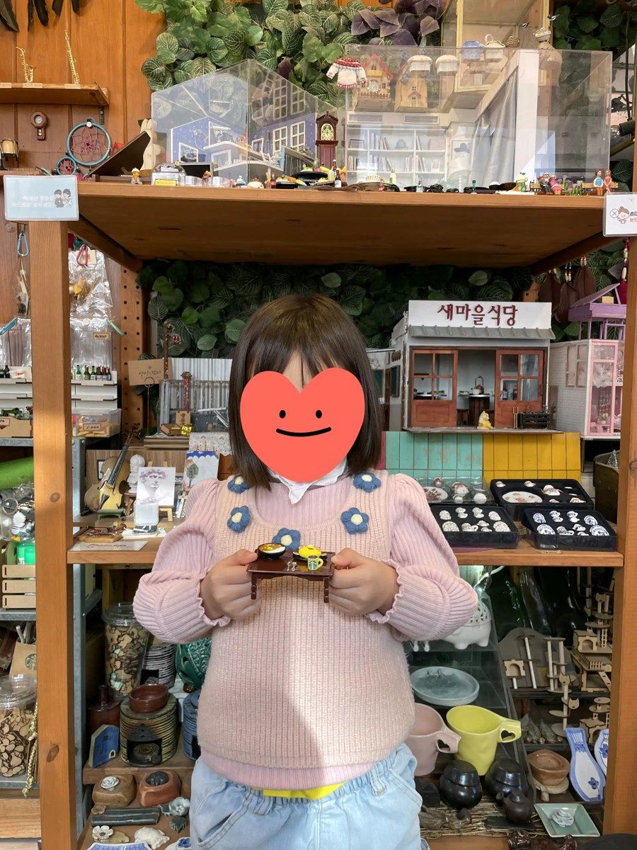 쌈지길 미니어처 공방 진열장 앞에 선 아이