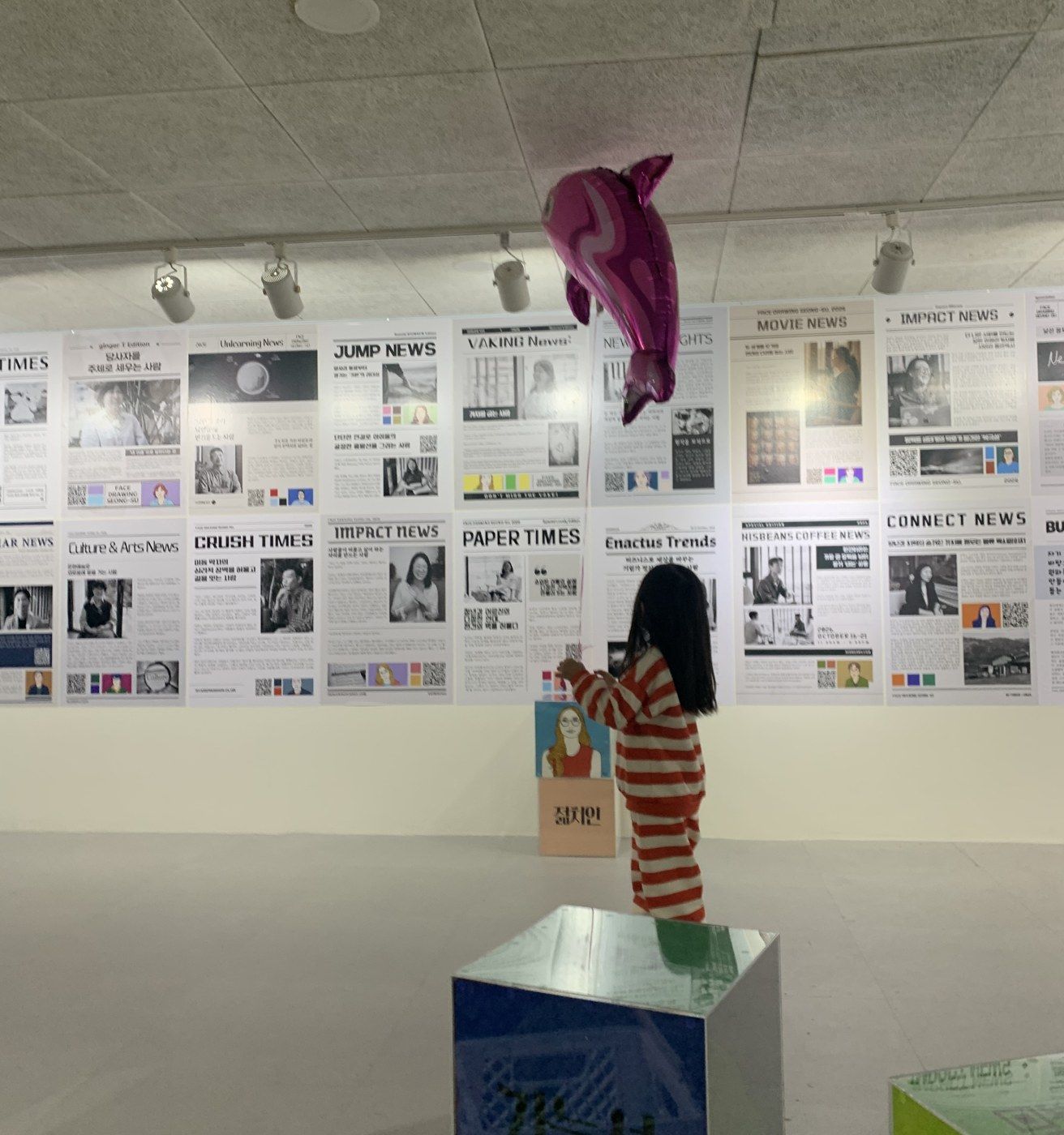 인터뷰 벽 앞에서 얼굴 그림을 올려다보는 아이